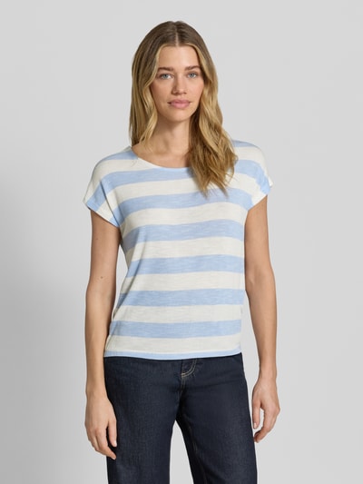 Frauenmodel trägt Boxy Fit T-Shirt aus Viskose-Mix Modell 'WIDE STRIPE' von Vero Moda im Streifenmuster und Optik:Allover-Muster, Farbkombination aus Hellblau und Weiß, Feinstrick-Textur, Rundhals und Kurzarm, Rumpfabschluss: Asymmetrisch, Ganzkörperansicht von vorne.