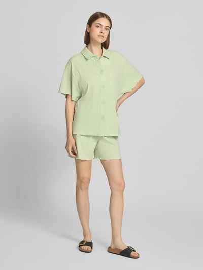 Frauenmodel trägt Relaxed Fit Bluse mit 1/2-Arm Modell 'Fleur' von OH APRIL aus mintgrünem Baumwoll-Mix mit Modal-Anteil, Ganzkörperansicht von vorne.
