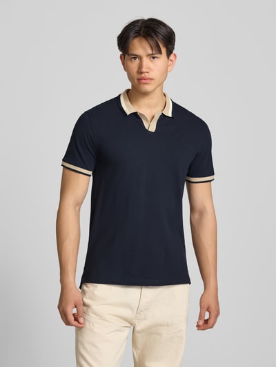Męski model nosi Regular Fit Poloshirt mit Label-Stitching Modell 'EVO' od Blend, czarna bawełna, krój regular fit, V-dekolt, widok całej sylwetki z przodu.