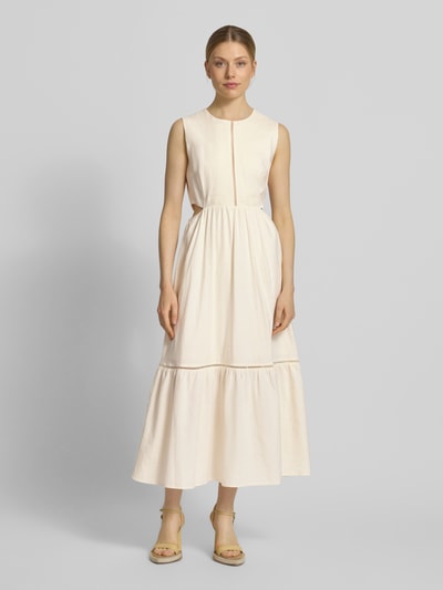 Frauenmodel trägt Midikleid aus Leinen-Mix mit Viskose-Anteil von JAKE*S STUDIO WOMAN in Creme mit Lochstitching und taillierter Passform, Rundhalsausschnitt, ärmelloses Design, Ganzkörperansicht von vorne. Rückenlänge 128 cm, Brustweite 41 cm bei Größe 36.