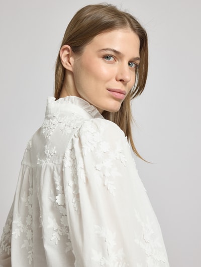 Frauenmodel trägt Regular Fit Hemdbluse mit floralem Besatz Modell 'Rufla' von Mango in Weiß mit Stehkragen, Nahaufnahme Oberkörper