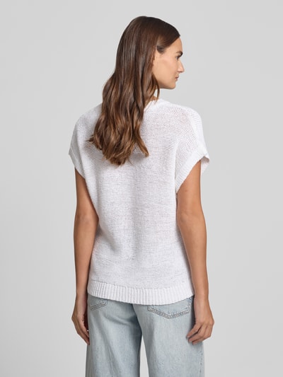 Vrouwenmodel draagt gebreid shirt met ronde hals en kapmouwen, model 'Estapper' van FREE/QUENT, regular fit, ruglengte maat S 55 cm, mouwlengte 24 cm, witte kleur, grof gebreide textuur, model van achteren gefotografeerd, ganzkörperansicht rückansicht.