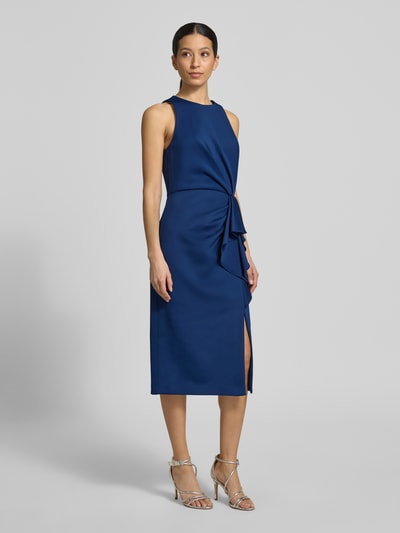 Frauenmodel trägt Cocktailkleid mit Rundhalsausschnitt und Volants von Adrianna Papell im tiefblauen Farbton, Material-Mix mit Stretch-Anteil, Gerader-Schnitt, Midikleid, Runde Ausschnittform und Volants, glatte Textur, Rückenlänge bei Größe 36 beträgt 114 cm, Brustweite 46 cm, Ganzkörperansicht von vorne.