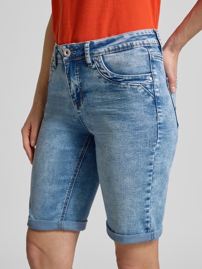 Frauenmodel trägt Regular Fit Shorts mit Viskose-Anteil Modell 'Parissa' von ZABAIONE in blauer Denim-Optik mit 5-Pocket-Design, Knopf- und Reißverschluss, Viskose-Baumwoll-Mix, Nahaufnahme Oberkörper.