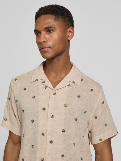 Männermodel trägt Regular Fit Freizeithemd mit Reverskragen von bugatti, beige mit dunkelbraunem Allover-Muster, Baumwoll-Mix mit Viskose-Anteil, Nahaufnahme Oberkörper.