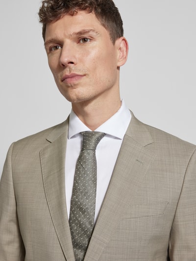 Männermodel trägt Slim Fit Anzug aus reiner Schurwolle Modell 'H-HUGE-2PCS-253' von BOSS in hellbeige mit feinem Allover-Muster, Nahaufnahme Oberkörper.
