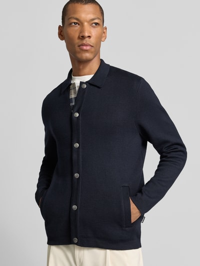Männermodel trägt dunkelblaue Regular Fit Strickjacke aus Baumwoll-Mix mit Woll-Anteil Modell 'Florcombe' von Barbour, Herren Strickjacke, Ganzkörperansicht von vorne.