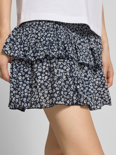 Frauenmodel trägt Ausgestellter Mini-Rock mit Volants Modell 'ZOEY' von Only, Optik:Allover-Muster floral, Regular-Fit, reine Baumwolle, Nahaufnahme Oberschenkel.