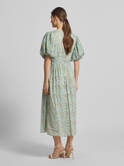 Frauenmodel trägt Cocktailkleid mit V-Ausschnitt und Puffärmeln von LACE & BEADS aus Reine Baumwolle in A-Linie als Midikleid, Ganzkörperansicht Rückansicht.