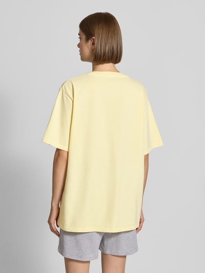 Frauenmodel trägt T-Shirt mit Rundhalsausschnitt Modell 'AM to PM' von OH APRIL in Gelb, Oversized, Baumwolle, Rückenansicht, Ganzkörperansicht Rückansicht.