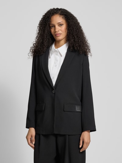 Frauenmodel trägt Relaxed Fit Blazer mit Reverskragen von ARMANI EXCHANGE in Schwarz mit Knopfverschluss und Pattentaschen, Nahaufnahme Oberkörper.