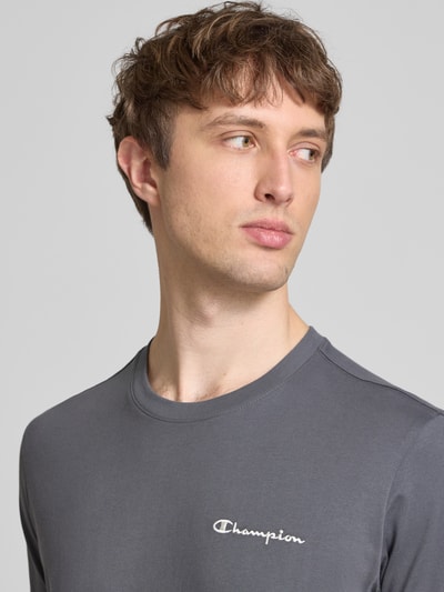 Männermodel trägt T-Shirt mit Label-Stitchings und Rundhalsausschnitt von CHAMPION, Reine Baumwolle, Regular-Fit, Nahaufnahme Oberkörper.