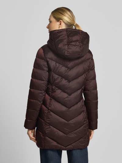 Frauenmodel trägt Steppmantel mit Kapuze und Reißverschlusstaschen von MICHAEL Michael Kors in Dunkelrot, glatte Oberfläche, Ganzkörperansicht Rückansicht. Gerader Schnitt, Kapuze mit Tunnelzug, Stehkragen, seitliche Reißverschlusstaschen, Rückenlänge 86 cm, Schulterbreite 43 cm, Brustweite 50 cm, Ärmellänge 62 cm.