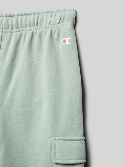 Produktfoto, Bermudas aus Baumwoll-Mix mit Label-Detail von CHAMPION in Hellgrün, gerade Passform, elastischer Bund, Cargotasche, Detailaufnahme