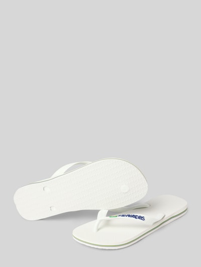 Produktfoto, weiße Slippers mit Logo-Detail Modell 'Brasil' von Havaianas aus Gummi, abgerundete Passform, offene Ferse, strukturierte Sohle, Absatzhöhe 2 cm, Schaftweite 7 cm