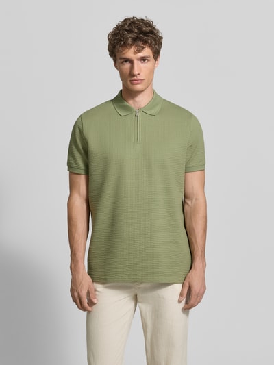 Męski model nosi Regular Fit Poloshirt mit Strukturmuster von MCNEAL, mieszanka bawełny, zamek błyskawiczny, krótki rękaw, długość tyłu 70 cm w rozmiarze M, fakturowany wzór, krój regular fit, Ganzkörperansicht von vorne.