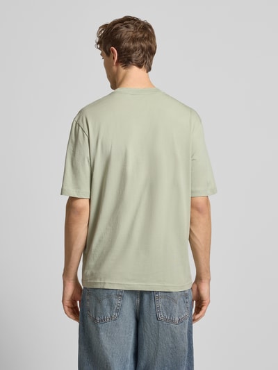 Męski model nosi Regular Fit T-Shirt aus reiner Baumwolle Modell 'NIEROFIX_U261' von HUGO, efekt: jednolity kolor, krótki rękaw, okrągły dekolt, aplikacja z wyhaftowanym logo, nadruk z motywem, bawełna, Ganzkörperansicht Rückansicht.