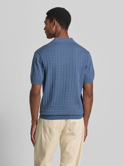 Męski model nosi Regular Fit Poloshirt mit Strukturmuster von Christian Berg Men z bawełny, Kołnierzyk polo, Dekolt w serek, Długość tyłu 69 cm, Długość rękawów 27 cm. Ganzkörperansicht Rückansicht.