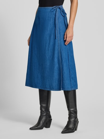 Frauenmodel trägt Ausgestellter Midi-Rock von s.Oliver RED LABEL in kräftigem Blau mit glatter Denim-Textur, Nahaufnahme Unterkörper.