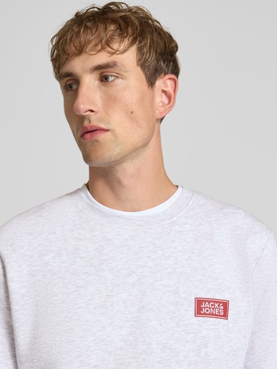 Männermodel trägt Sweatshirt mit Label-Print Modell 'RUSH' van JACK & JONES van katoenmix, los model, ronde hals, ribboorden, labelprint, Nahaufnahme Oberkörper.