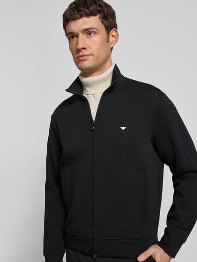 Männermodel trägt Regular Fit Sweatjacke mit Logo-Stitching von Emporio Armani aus elastischem Baumwoll-Mix in Schwarz, Nahaufnahme Oberkörper.