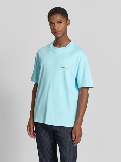 Männermodel trägt Oversized T-Shirt mit Label-Print von Lindbergh in Hellblau, Reine Baumwolle, Rundhalsausschnitt, Rückenlänge 70 cm, Ganzkörperansicht von vorne.