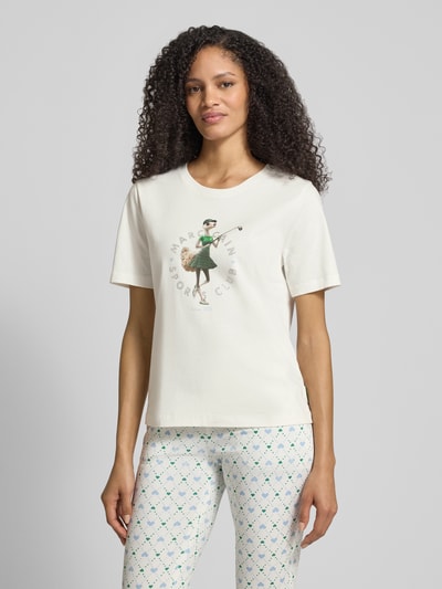 Frauenmodel trägt Regular Fit T-Shirt mit Ziersteinbesatz von Marc Cain, Motiv-Print, reine Baumwolle, Rundhalsausschnitt, Ganzkörperansicht von vorne.