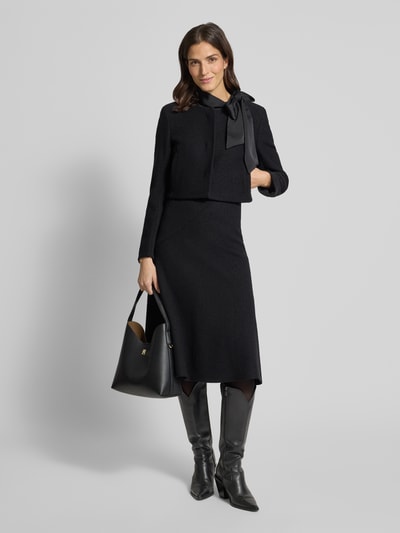 Modelka kobieca nosi Boxy Fit Kurzblazer aus reiner Schurwolle Modell 'JICENA' od BOSS, czarny, jednolity, długie rękawy, okrągły dekolt, widok całej sylwetki z przodu.