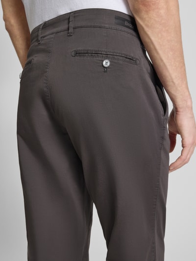 Mężczyzna nosi spodnie materiałowe Straight Fit Stoffhose mit Lyocell-Anteil Modell 'Everest' von BRAX, mieszanka lyocellu i bawełny, w kolorze grafitowym, wpuszczane kieszenie, kieszonka na monety, zapięcie na guzik i zamek błyskawiczny, szerokość w rozmiarze 50: 46 cm, długość wewnętrzna nogawki: 82 cm, widok z tyłu zbliżenie bioder