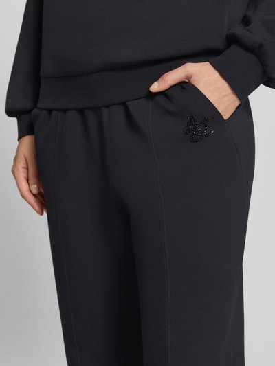 Vrouwenmodel draagt Wide Fit broek uit viscosemix met elastische band, steekzakken, Binnenbeenlengte maat S 79 cm, van Liu Jo, detailopname.