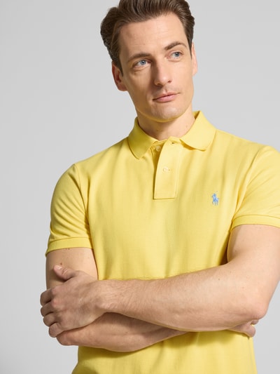 Männermodel trägt Regular Fit Poloshirt aus reiner Baumwolle von Polo Ralph Lauren in Gelb, Piqué-Struktur, Logo-Detail, Nahaufnahme Oberkörper.
