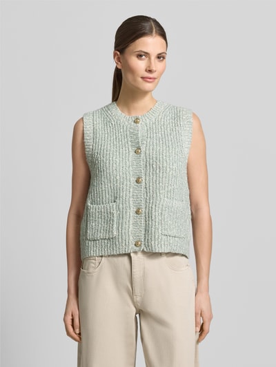 Frauenmodel trägt Strickweste Melange Effekt mit Schmuckknopf von Christian Berg Woman, hellgrün meliert, gerippte Struktur, Regular Fit, Nahaufnahme Oberkörper.
