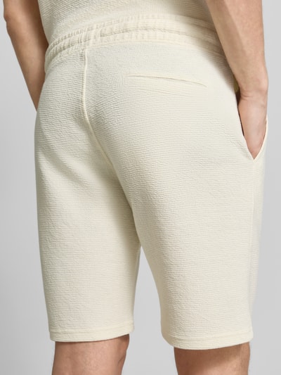 Männermodel trägt Sweatshorts mit elastischem Bund von MCNEAL im Elastischer-Material-Mix mit Strukturmuster, Eingriff- und Gesäßtasche, Gerade Passform, Ganzkörperansicht Rückansicht.