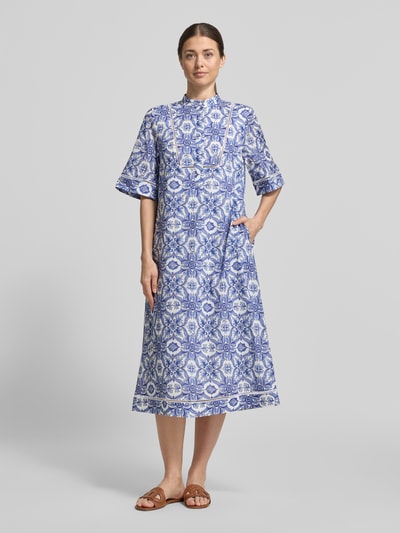 Frauenmodel trägt Midikleid mit verdeckter Knopfleiste Modell 'Desa' von JOOP! in Blau-Weiß mit Allover-Muster aus reiner Baumwolle, gerader Schnitt, Stehkragen, Halbarm, Ganzkörperansicht von vorne.
