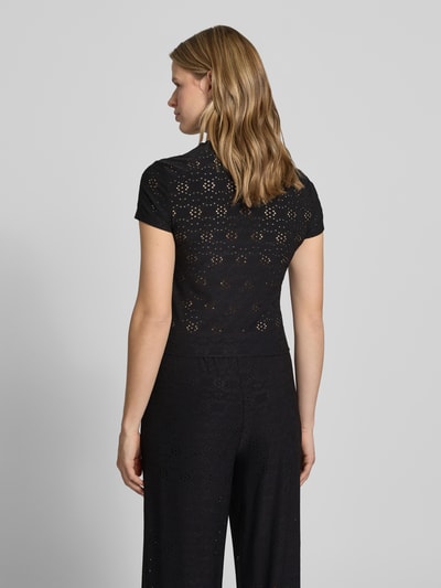 Frauenmodel trägt Relaxed Fit T-Shirt mit Ausbrenner-Effekt Model 'SMILLA' von Only, Schwarz mit Lochmuster, Ganzkörperansicht Rückansicht.