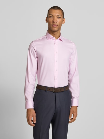 Mężczyzna model nosi Slim Fit Business-Hemd aus Baumwolle mit Kentkragen von SEIDENSTICKER w jasnoróżowym kolorze, krój slim fit, kołnierzyk typu kent, listwa guzikowa, długość tyłu w rozmiarze 40: 77 cm, szerokość ramion w rozmiarze 40: 45 cm, długość rękawów w rozmiarze 40: 67 cm, całkowity widok z przodu.
