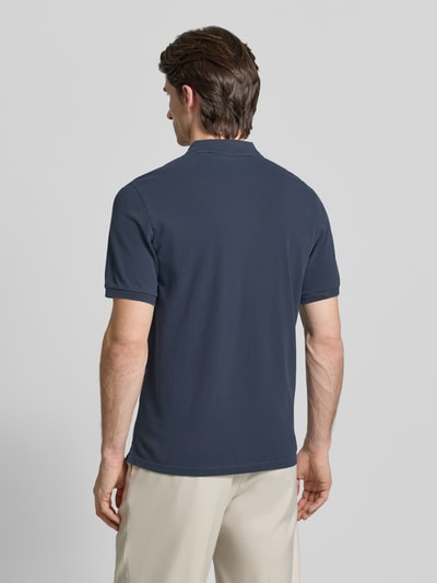 Männermodel trägt Poloshirt aus Baumwolle von MARC O’POLO DENIM in Dunkelblau, Piqué-Struktur, gerader Schnitt, Ganzkörperansicht Rückansicht