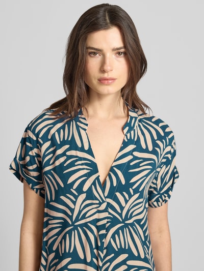Modelka kobieca nosi Relaxed Fit Kleid aus reiner Viskose Modell 'Mary' od ZABAIONE, wzór kwiatowy, krótki rękaw, kolor niebiesko-beżowy, dekolt typu tunika, długość tyłu w rozmiarze S: 94 cm, szerokość w rozmiarze S: 52 cm, długość rękawa w rozmiarze S: 18 cm, zbliżenie na górną część ciała.