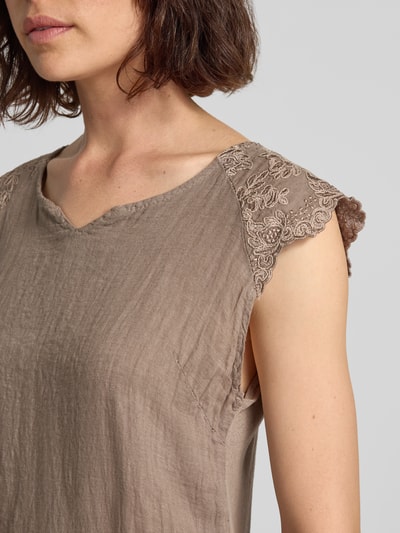 Frauenmodel trägt Minikleid aus Leinen-Mix mit Stitchings von ZABAIONE, A-Linie, strukturierte Textur, Nahaufnahme Oberkörper.