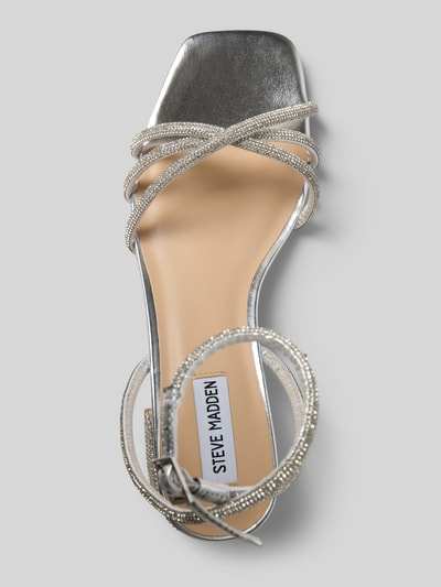 Produktfoto, Sandalette mit Ziersteinbesatz Modell 'Cerena' von Steve Madden in Silber, Riemen mit Dornschließe, Blockabsatz, Absatzhöhe 5 cm, Größe 40, moderne Sandalen-Form, glänzende Oberfläche und feine Riemen-Details.