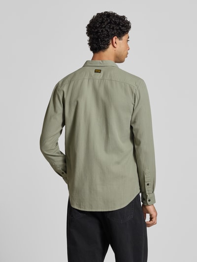 Männermodel trägt Slim Fit Freizeithemd mit Label-Patch Modell 'Marine' von G-Star Raw aus reiner Baumwolle, langärmelig, grün, Ganzkörperansicht Rückansicht.