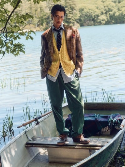Männermodel trägt Gerade Hose aus Baumwoll-Mix von Polo Ralph Lauren in Dunkelgrün, weite Form, natürliche Umgebung, Ganzkörperansicht von vorne.