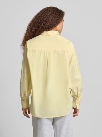 Frauenmodel trägt Regular Fit Bluse aus Baumwolle Modell 'EMMA' von Noisy May in zartem Gelb mit Hemdblusenkragen und Knopfleiste, Rückenlänge 73 cm, Ärmellänge 56 cm, Ganzkörperansicht Rückansicht.