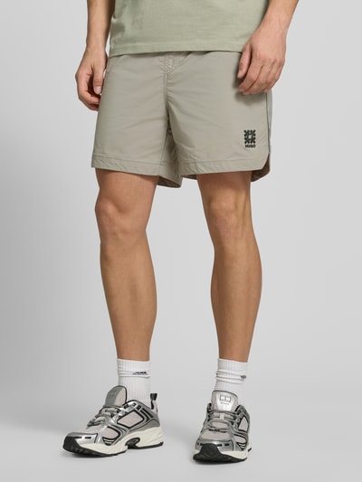 Männermodel trägt Regular Fit Shorts mit Label-Applikation Modell 'COLAS262S' von HUGO, Optik: Unifarben, Eingrifftaschen, Ganzkörperansicht von vorne.