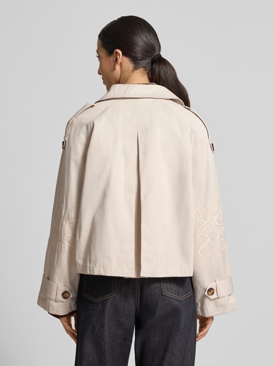 Frauenmodel trägt Kurzer Trenchcoat mit Eingrifftaschen von Smith and Soul aus Baumwoll-Mix, kurze Passform, zweireihig, Umlegekragen, Rückenlänge 55 cm, Schulterbreite 43 cm, Brustweite 62 cm, Ärmellänge 60 cm, helle Farbe, strukturierter Stoff, Ganzkörperansicht Rückansicht.