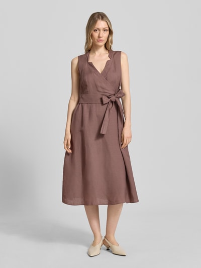 Kobiece modelka nosi sukienka midi z mieszanki lnu i wiskozy w kopertowym stylu od Christian Berg Woman Selection, linia a, dekolt w serek, długość tyłu w rozmiarze 36 to 120 cm, szerokość w rozmiarze 36 to 45 cm, kolor brązowy, matowa faktura, całkowity widok z przodu.