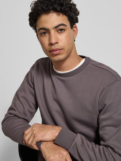 Männermodel trägt Regular Fit Sweatshirt aus Baumwoll-Mix Modell 'CERES' von Only & Sons in Unifarben mit Rundhalsausschnitt, Nahaufnahme Oberkörper.