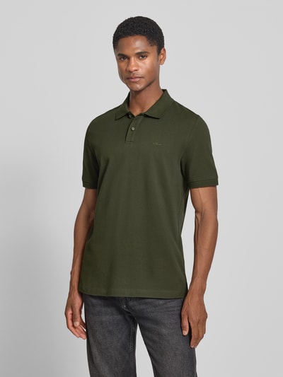 Männermodel trägt Regular Fit Poloshirt aus reiner Baumwolle von s.Oliver RED LABEL in Dunkelgrün, Ganzkörperansicht von vorne.