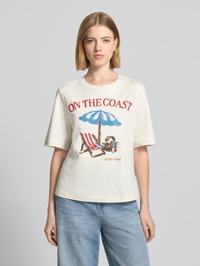 Frauenmodel trägt Relaxed Fit T-Shirt mit Ziersteinbesatz von Rich & Royal in Creme, Reine Baumwolle, Rundhalsausschnitt, Rückenlänge 57 cm, Ganzkörperansicht von vorne.