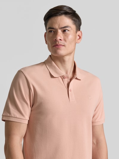 Männermodel trägt Slim Fit Poloshirt mit Stitching von Jack & Jones Premium in zartem Rosa, reine Baumwolle, Nahaufnahme Oberkörper.